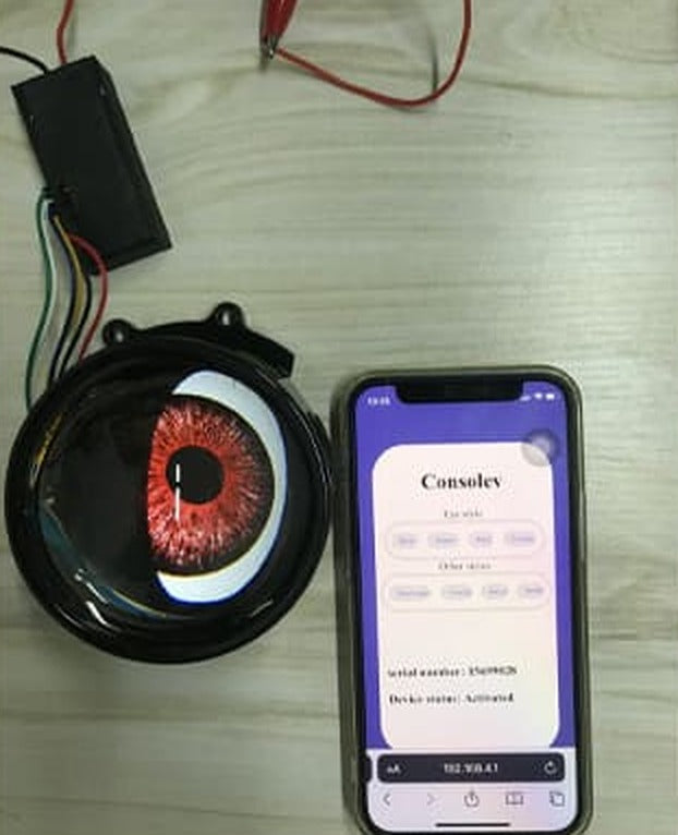 Phone showing the lens control page at 192.168.4.1 next to a lit red devil eye lens